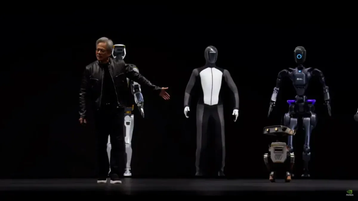 Man gestures toward a row of robots, black background. Robots include humanoid and dog-like designs.