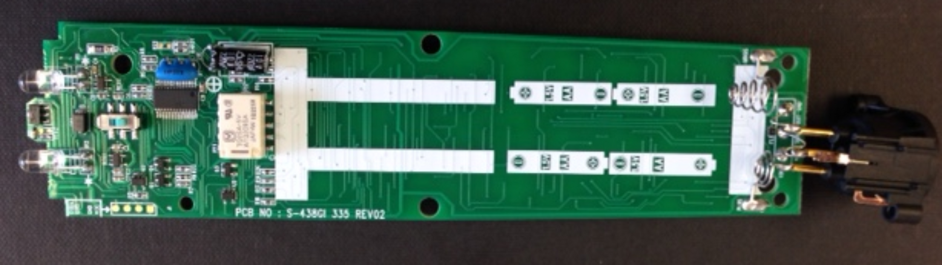 Green circuit board with white markings and various electronic components.