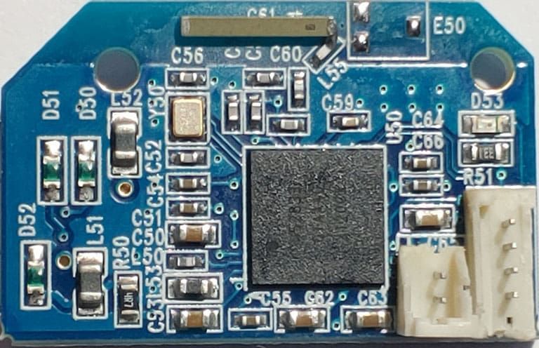 Blue circuit board with numerous electronic components, including resistors, capacitors, and a central chip.