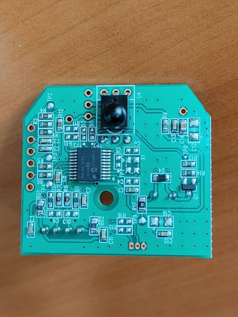 Green circuit board with central processor, camera lens, and various electronic components.