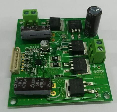 Green circuit board with electronic components: capacitors, transistors, and connectors for a motor.
