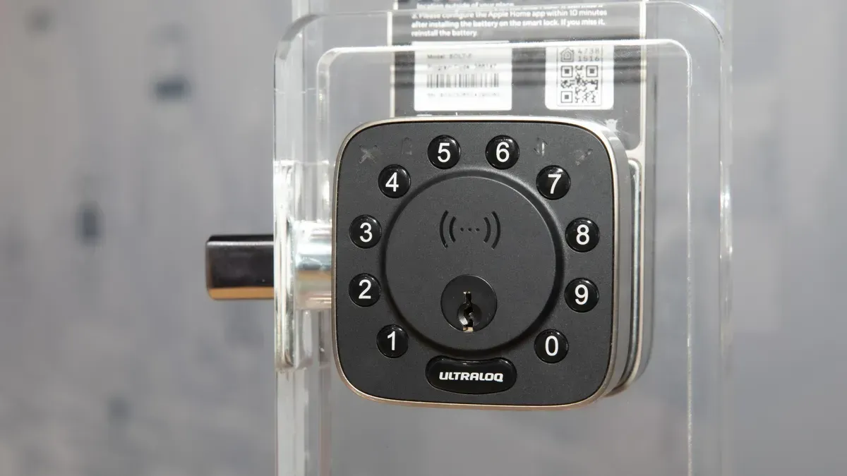 Close-up of a black keypad door lock with numbers 0-9. It has a keyhole and a small RFID icon.