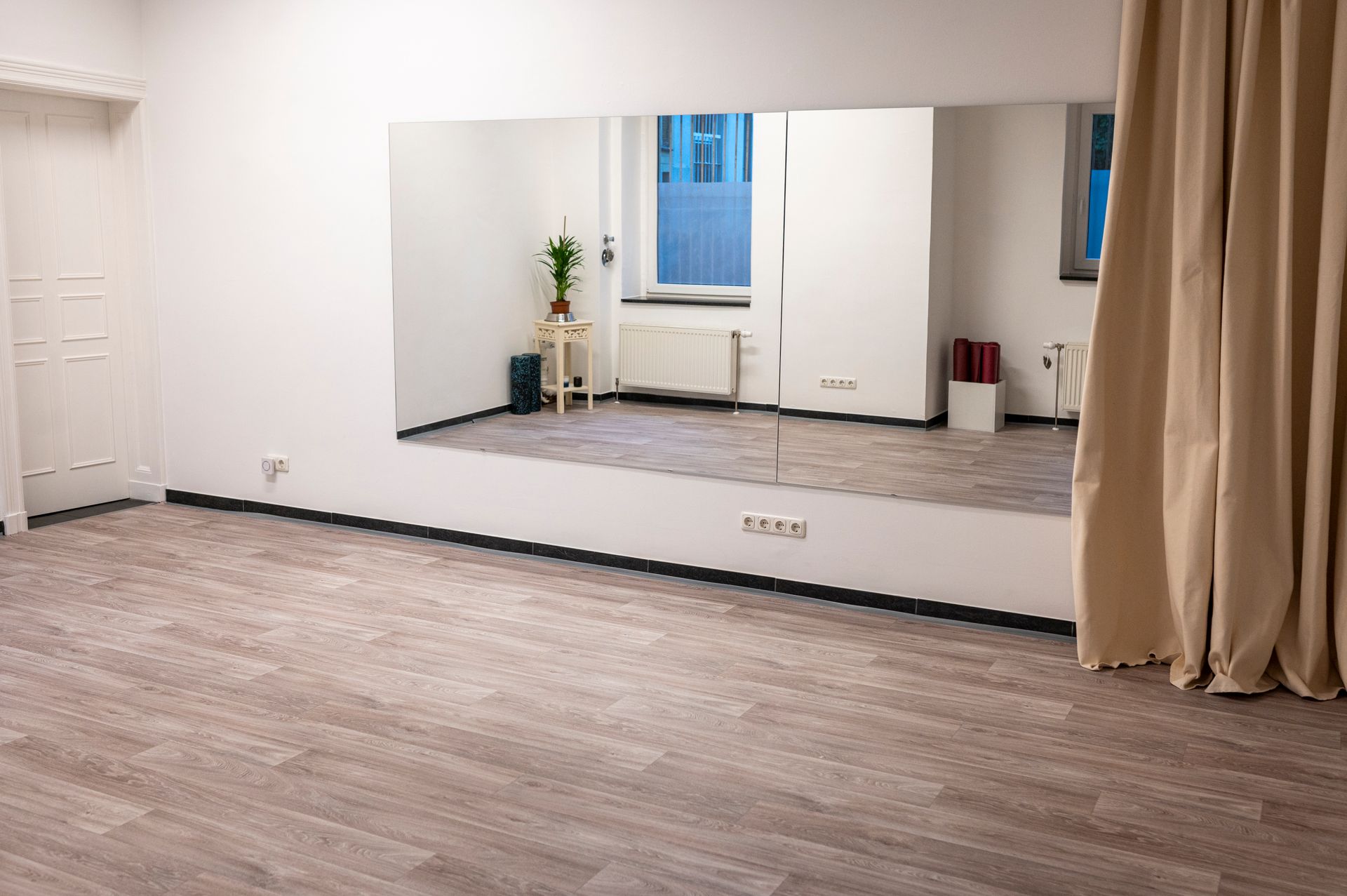 An empty room with a large mirror on the wall