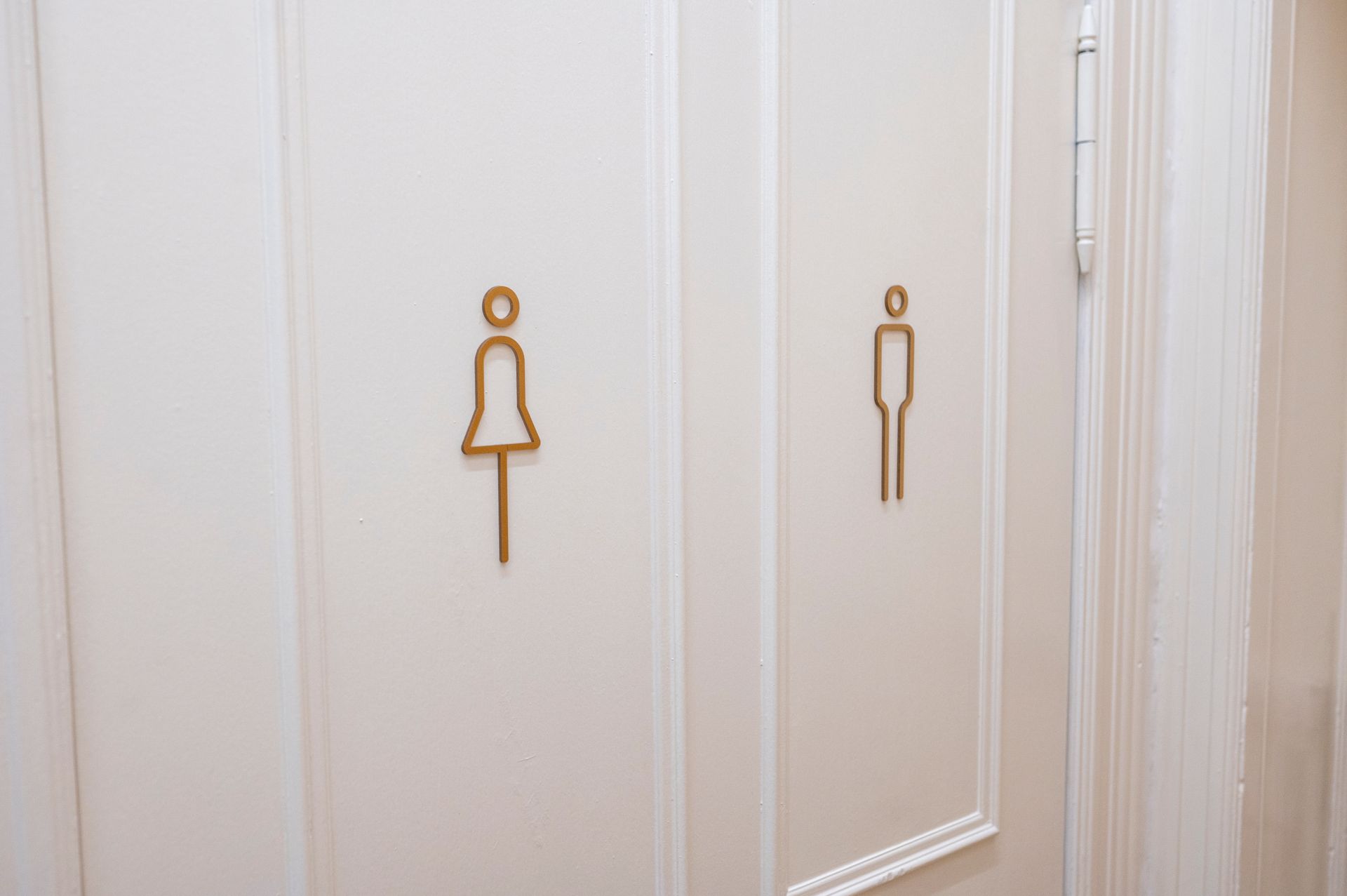A man and a woman are standing next to each other in a bathroom.