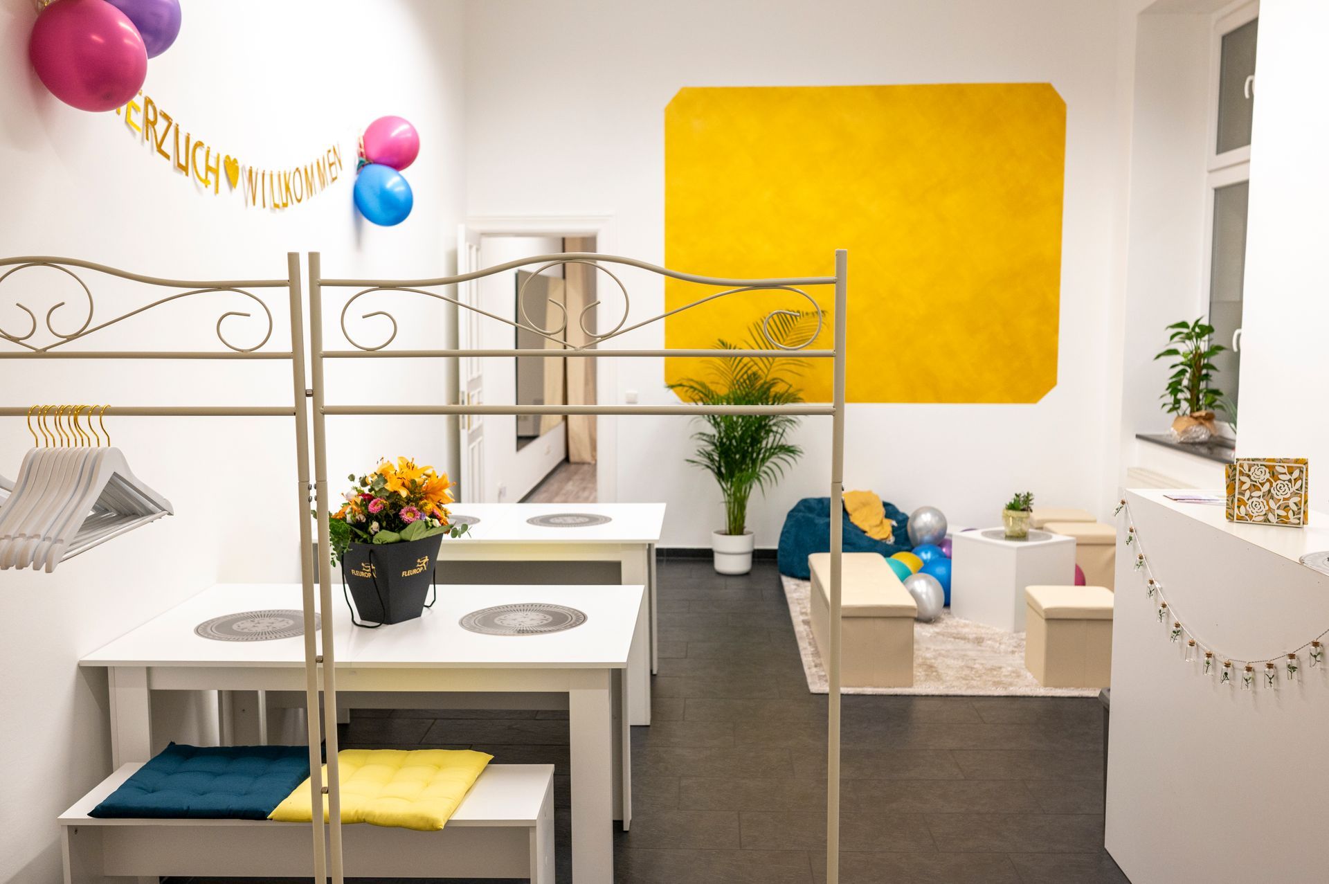 A room with tables and chairs and balloons on the wall