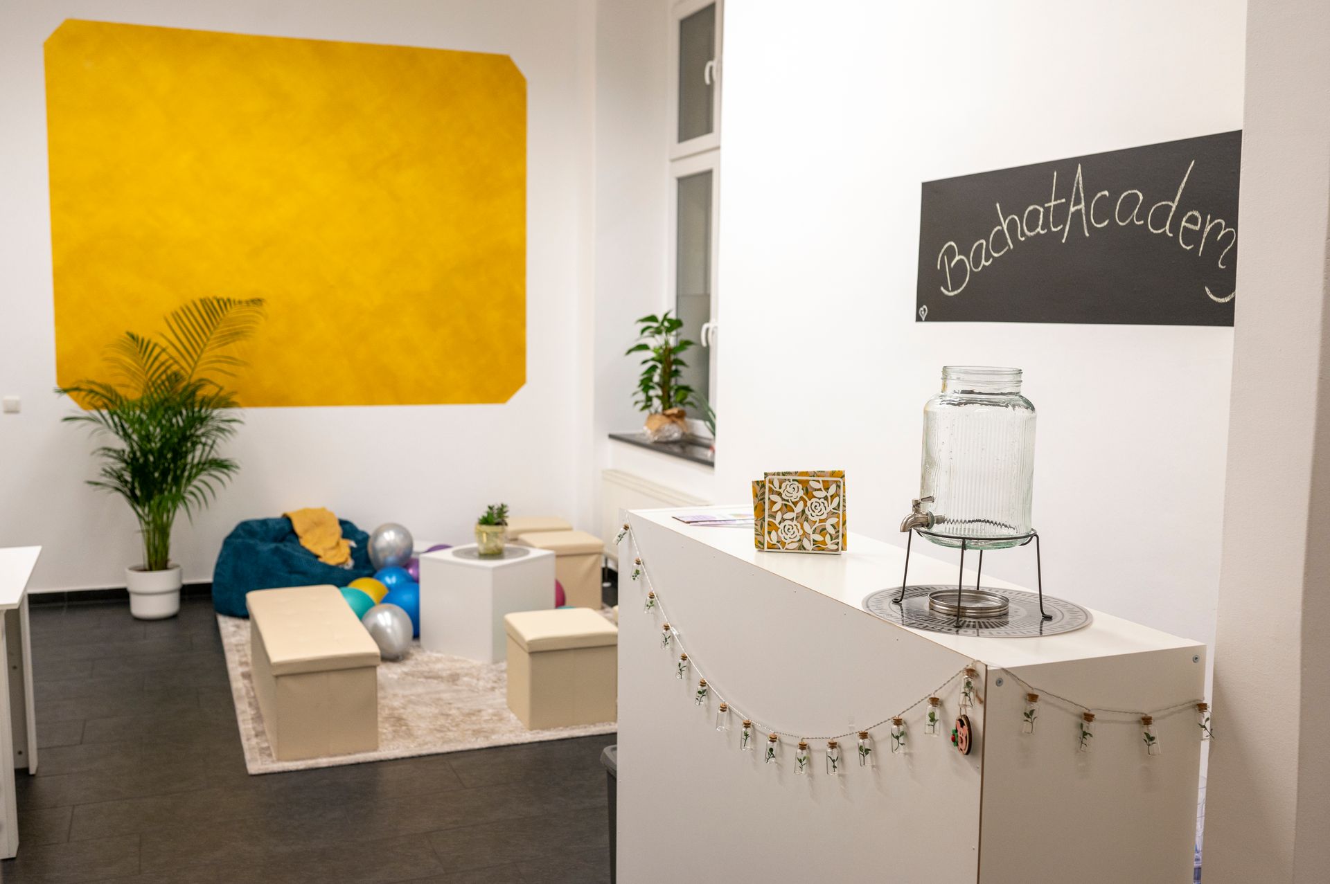 A room with a yellow wall and a chalkboard that says ' garten ' on it