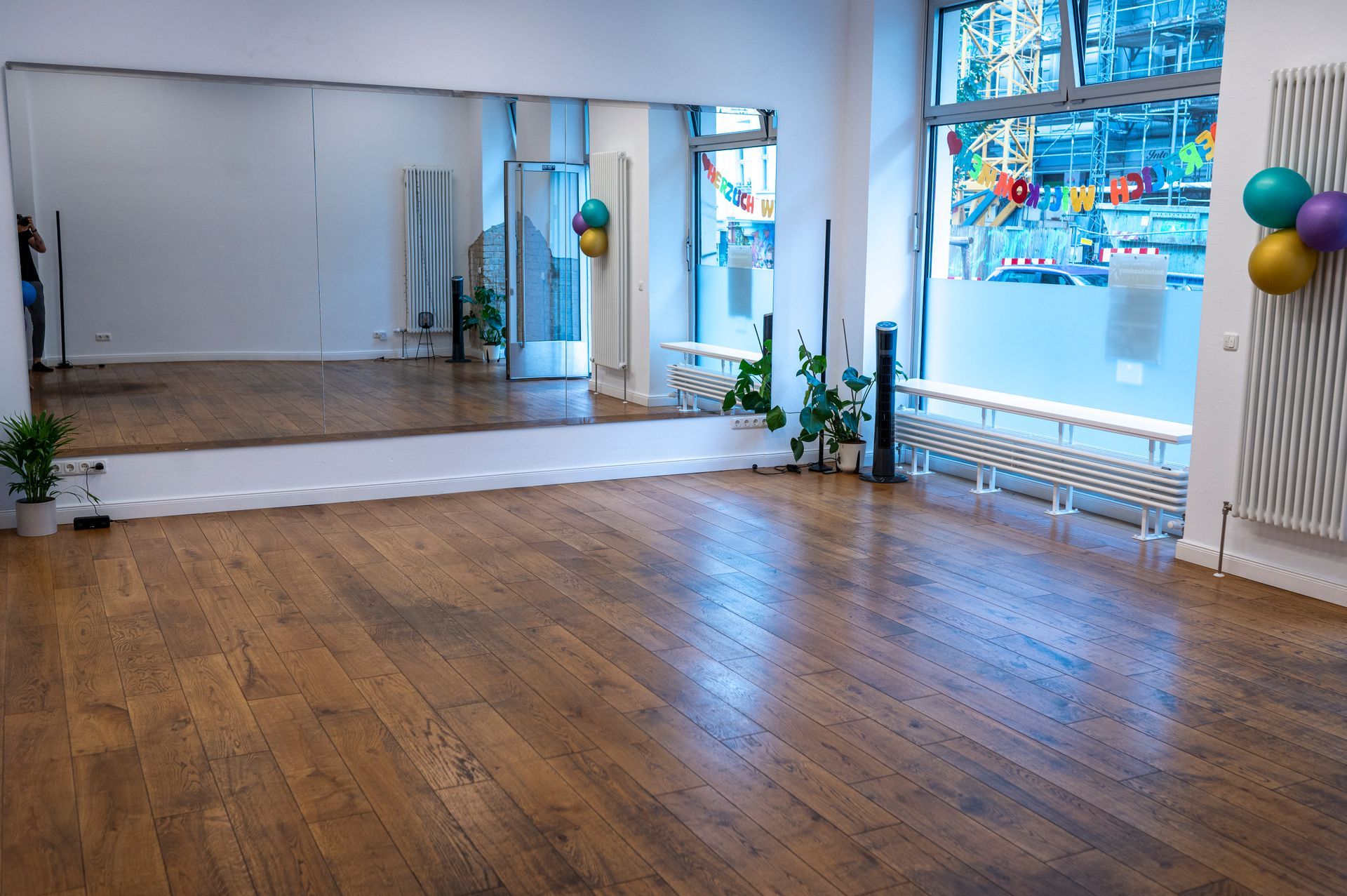 An empty room with a large mirror and balloons on the wall