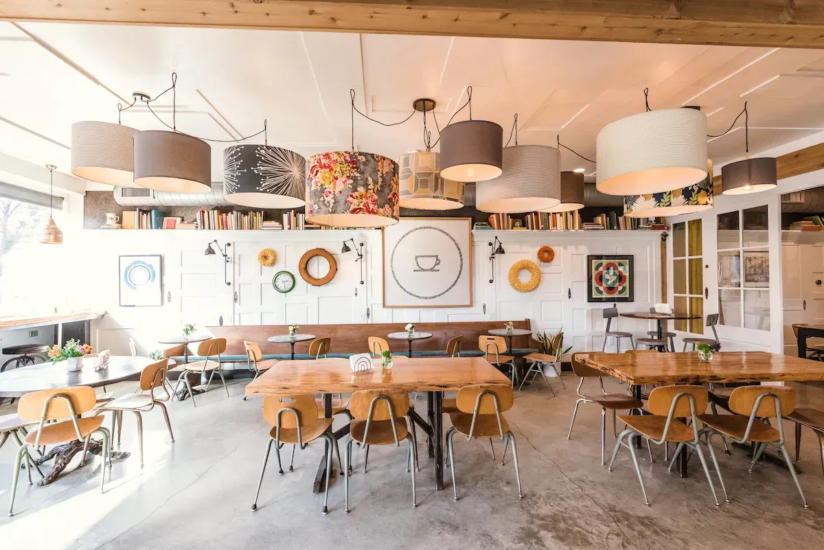 Wyoming, Ohio restaurant interior with wooden tables, chairs, and decorative wall art.