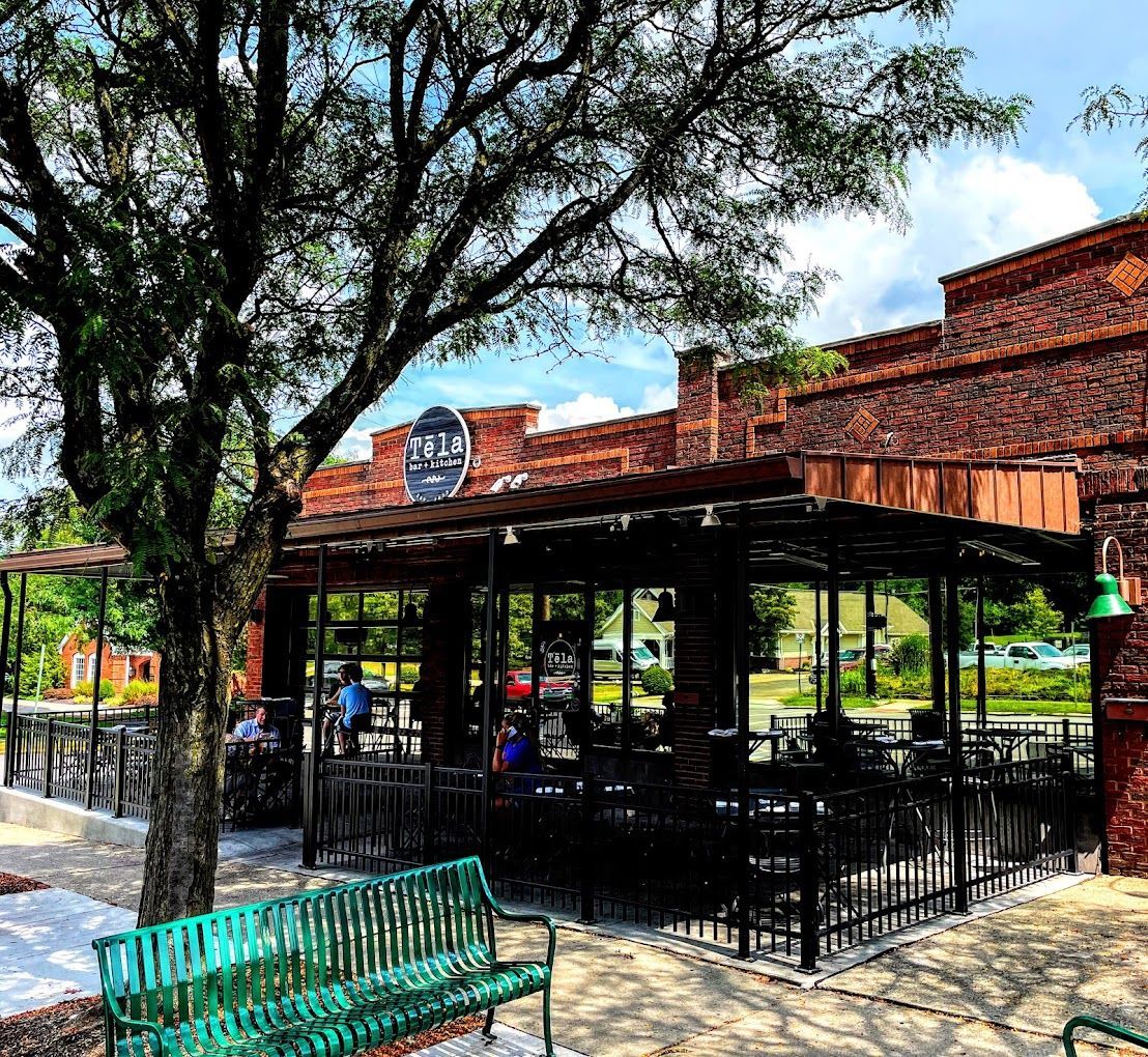 Mela Urban Bistro restaurant in Wyoming, Ohio with brick exterior, outdoor patio, and large tree in front.