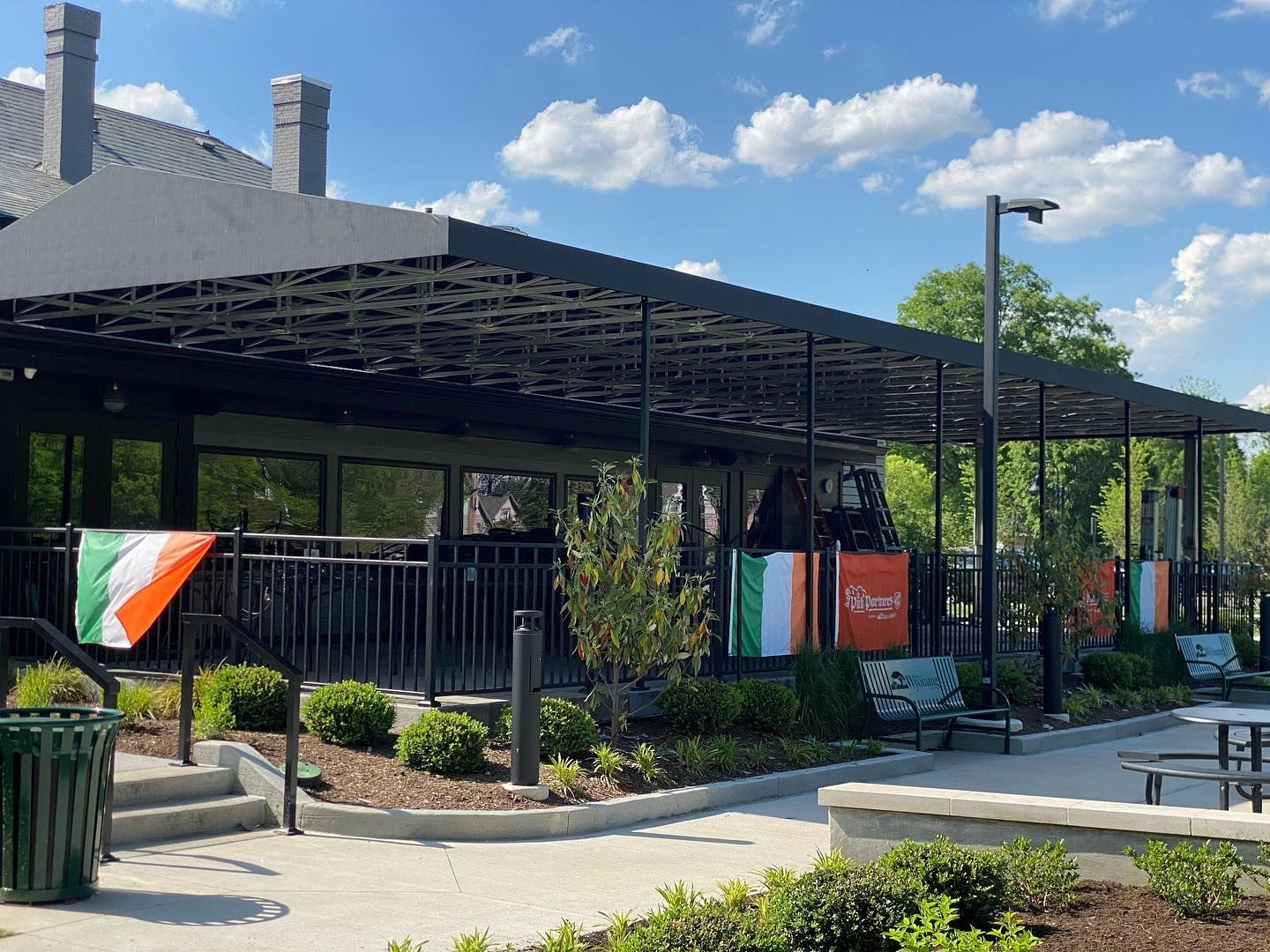 Gilligan’s on the Green restaurant patio in Wyoming, Ohio with outdoor seating and Irish flags.
