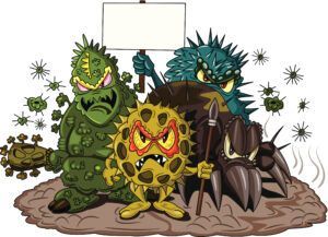 Cartoon illustration of four colorful, angry-looking germ characters standing on a patch of dirt holding a blank sign.