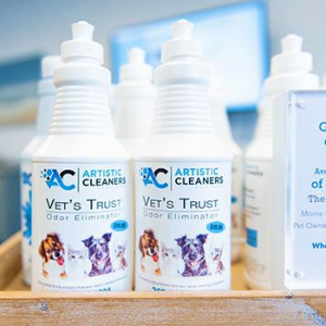Bottles of Artistic Cleaners Vet's Trust odor eliminator featuring illustrations of dogs and cats on a retail shelf.