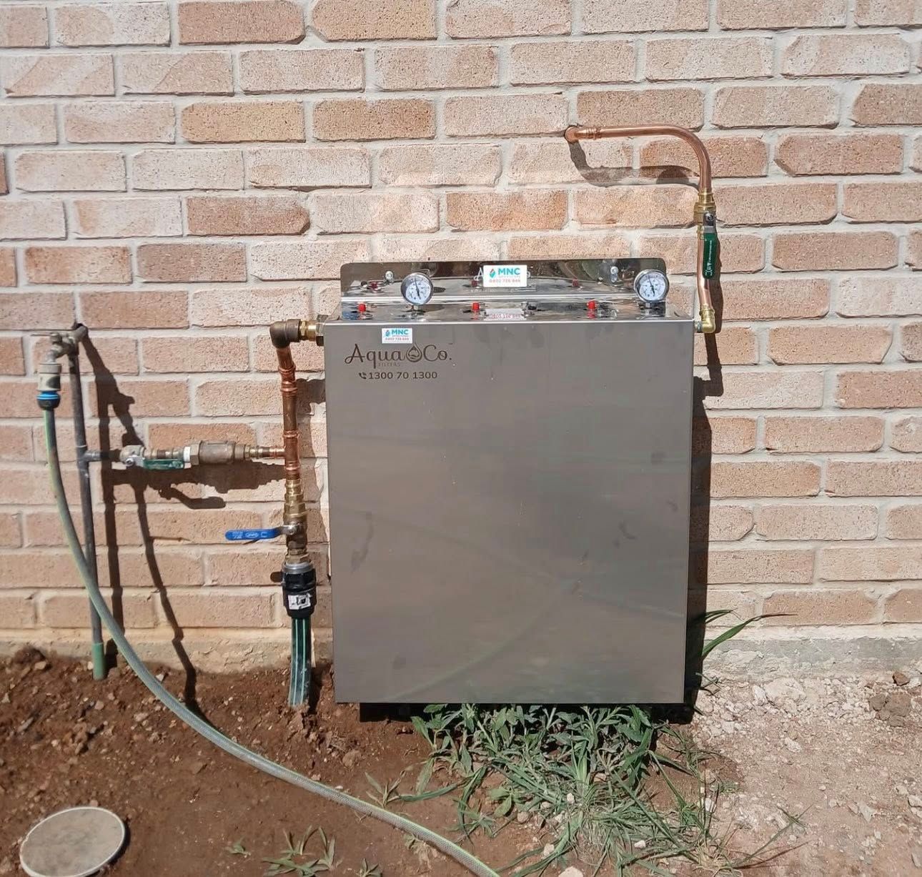 A Metal Equipment Box Mounted on a Brick Wall — APD Plumbing In Coffs Harbour, NSW