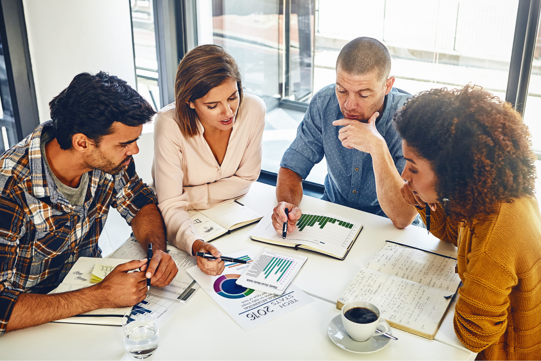 A group of people are sitting around a table having a meeting.