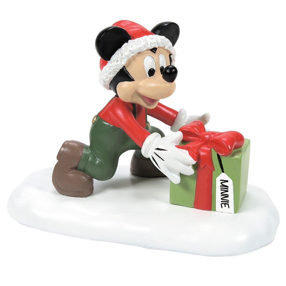 Mickey Mouse met kerstmuts op, die een groen cadeautje inpakt met een rode strik. Op een besneeuwde achtergrond.