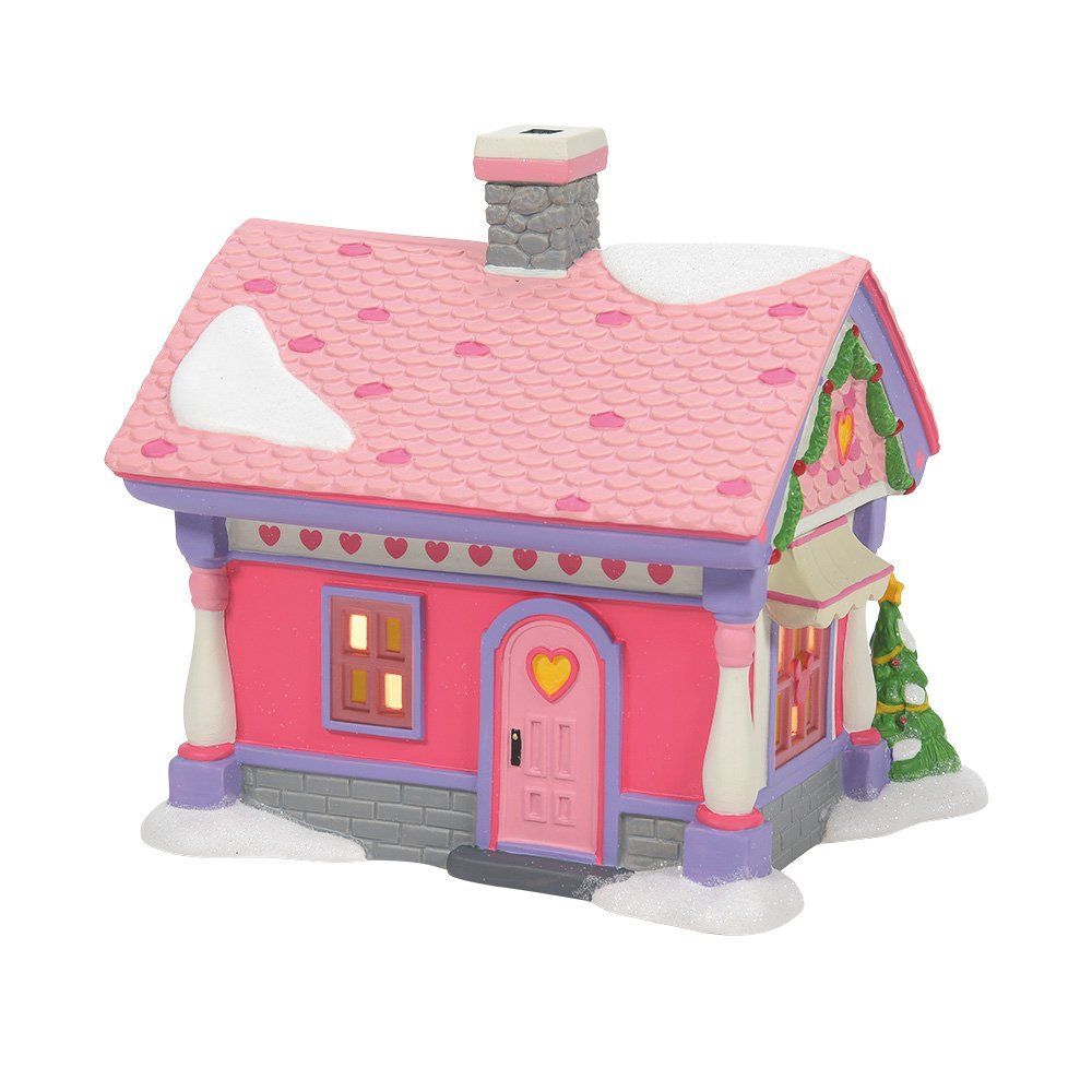 Roze en witte kerstdorpwinkel met een uithangbord.