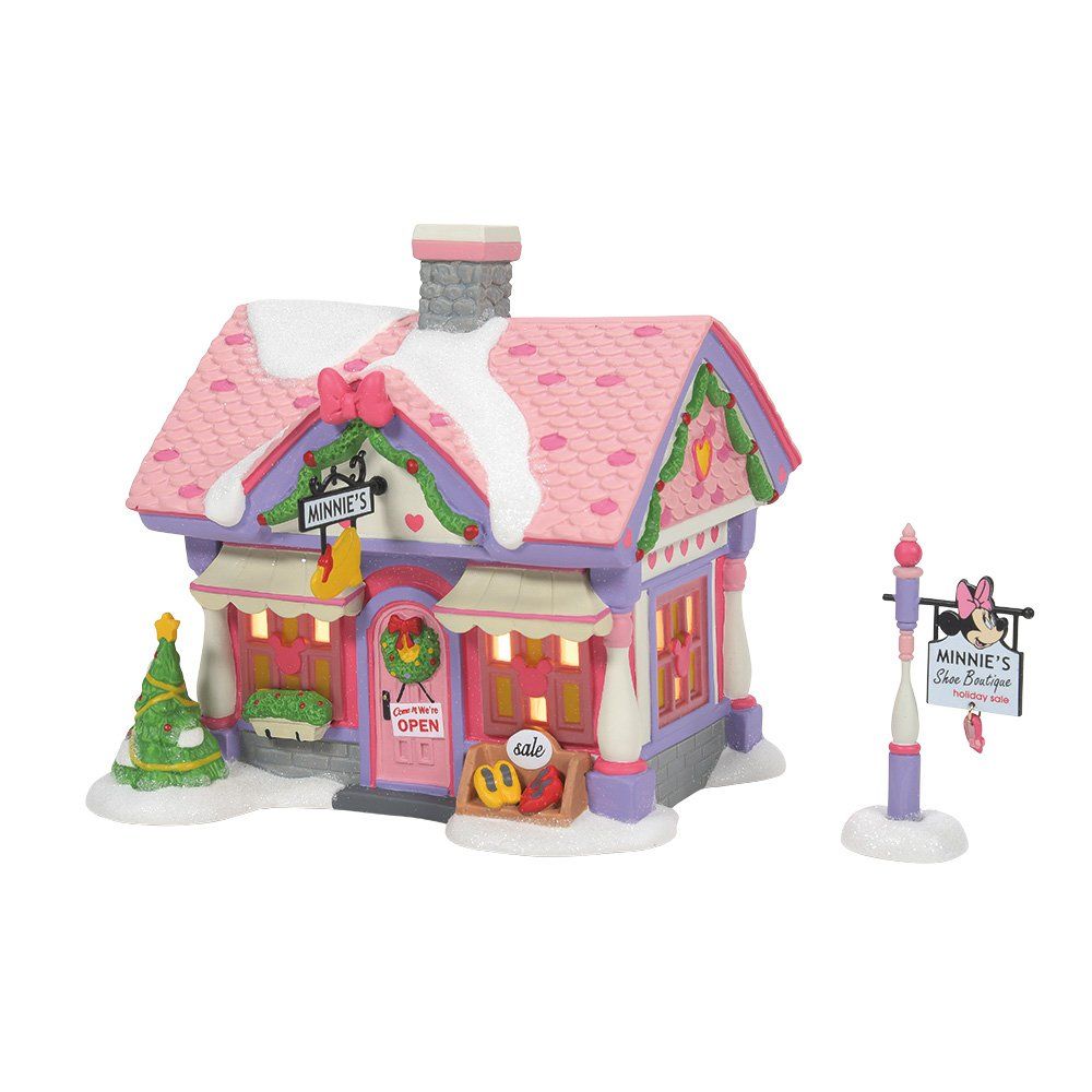 Roze en witte kerstdorpwinkel met een uithangbord.
