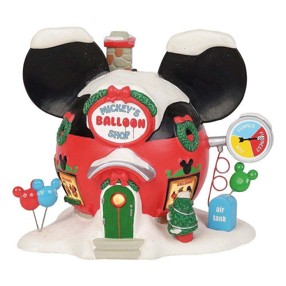 Disney-kerstdecoratie: een ballonnenwinkel in de vorm van Mickey Mouse, bedekt met sneeuw. Rood gebouw, groene deur en een dak in de vorm van Mickey Mouse-oren.