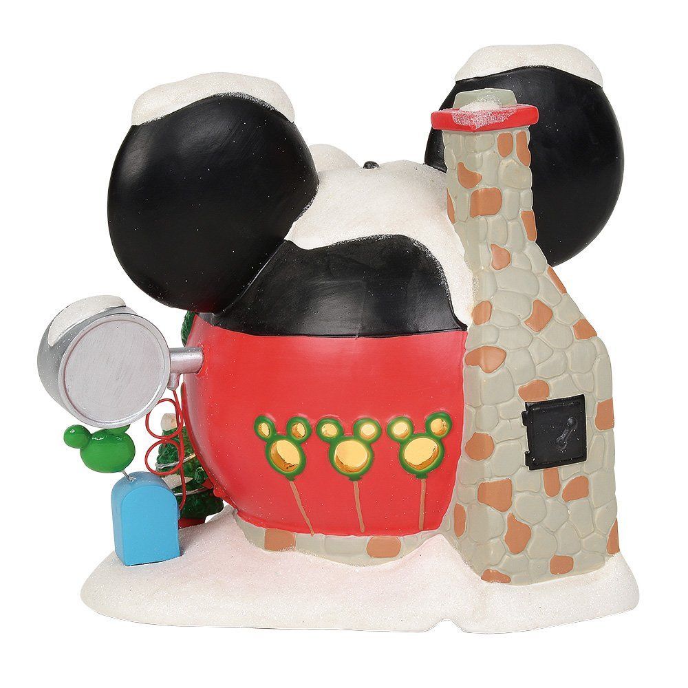 Disney-kerstdecoratie: een ballonnenwinkel in de vorm van Mickey Mouse, bedekt met sneeuw. Rood gebouw, groene deur en een dak in de vorm van Mickey Mouse-oren.