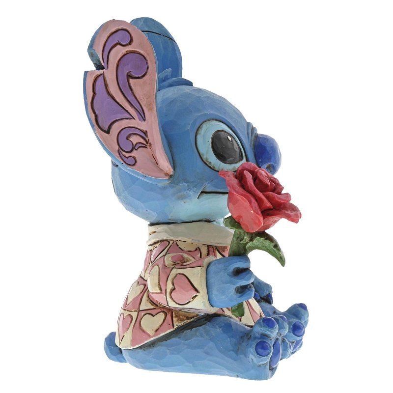 Een figuurtje van Blue Stitch met een rode roos in haar hand en een shirt met hartjesmotief.