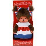 Monchhichi-pop in een doos, gekleed in een rood, wit en blauw jurkje.