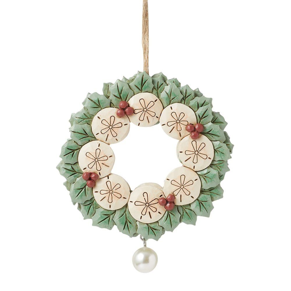 Een kransornament in kuststijl met zeeschelpen, groen, bessen en een parel.