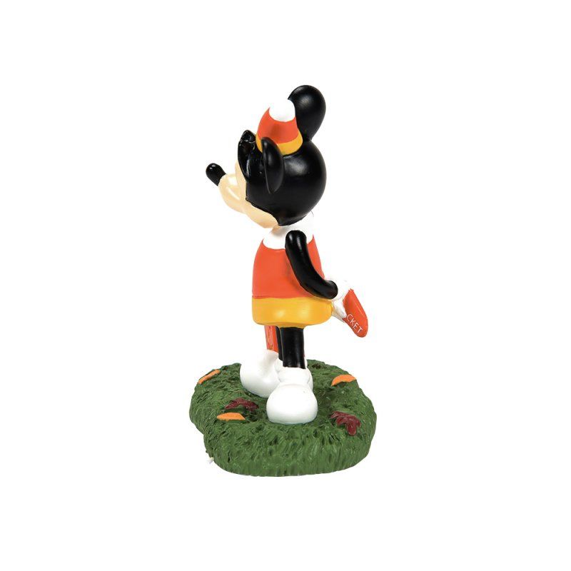 Mickey Mouse in Halloweenkostuum staat in het gras met een emmer snoep.