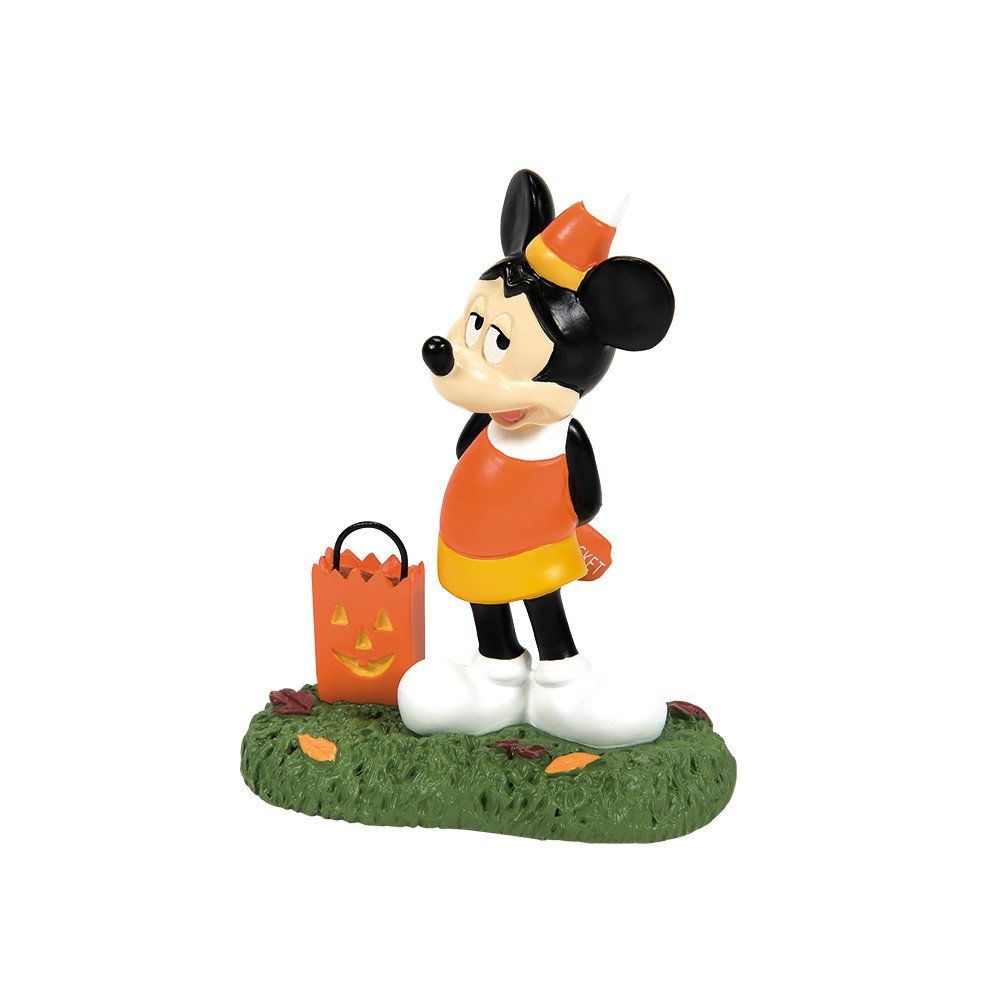 Mickey Mouse in Halloweenkostuum staat in het gras met een emmer snoep.