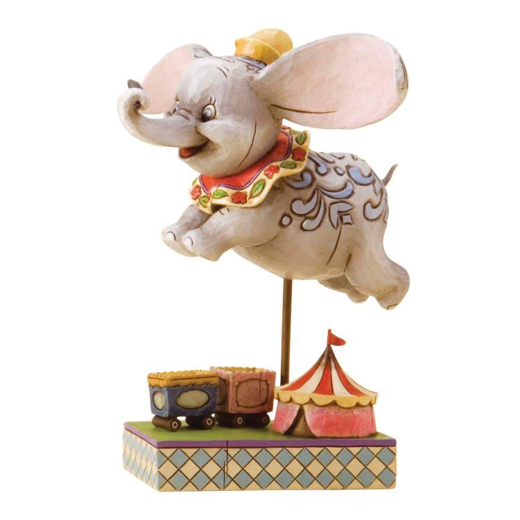 Dumbo-figuurtje dat vliegt met een circustrein en een tent op een voetstuk. Kleuren: grijs, roze, rood, blauw en geel.