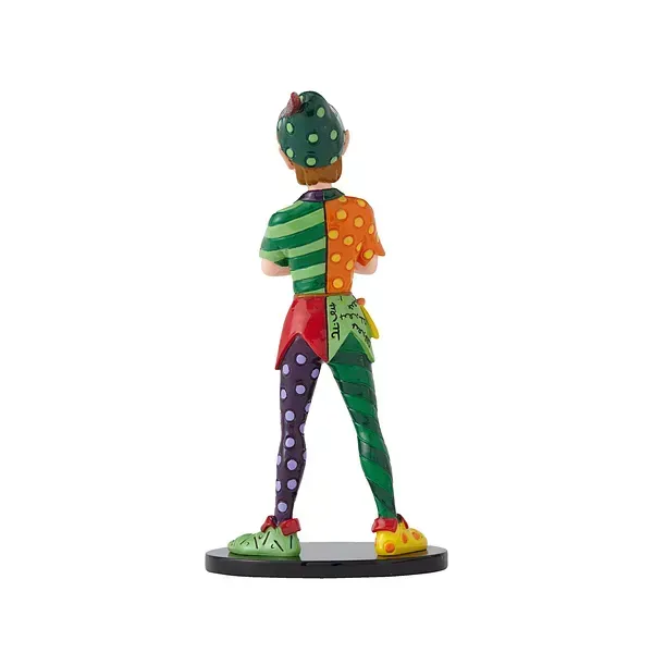 Standbeeld van een personage in een bonte verzameling kleurrijke kleding, staand met de armen over elkaar, op een zwarte sokkel.