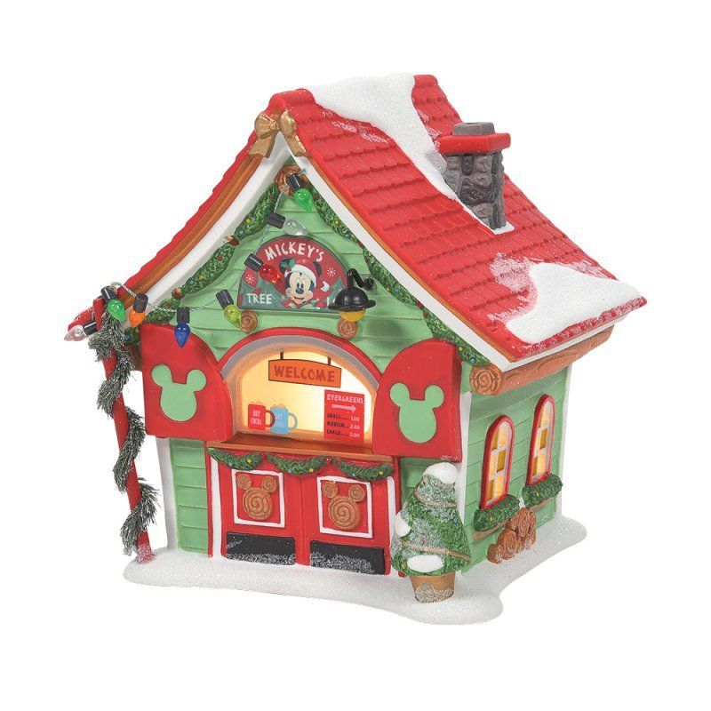 Een kerstspeelgoedwinkel met Disney-thema, een rood dak, groene muren en sneeuw. Verlichte ramen en een Mickey Mouse-bord zijn zichtbaar.