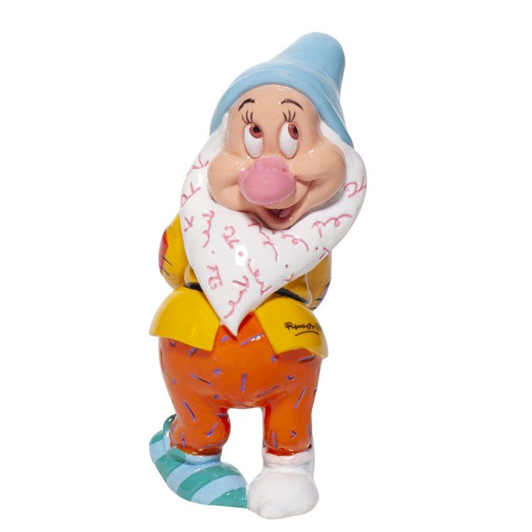Een sullig figuurtje met een blauwe hoed, een roze neus en een oranje broek met kleurrijke patronen.