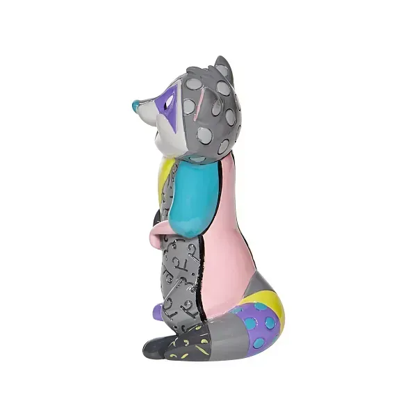 Een kleurrijk wasbeerfiguurtje met stippen, lappen en een paars masker, dat rechtop staat.