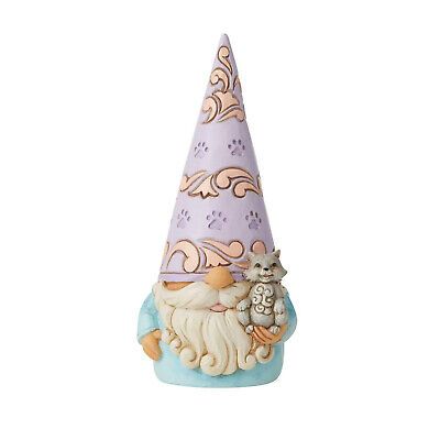 Een kabouterbeeldje met lichtblauwe kleren, een lange witte baard, een grijze kat in zijn armen en een hoge lila hoed met poten.