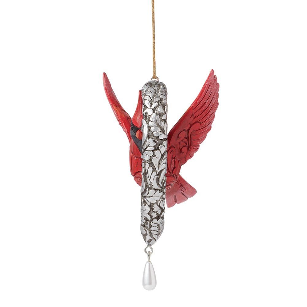 Rood kardinaalornament met zilveren middenstuk, hangend aan een gouden koord, met een witte peervormige kraal aan de onderkant.