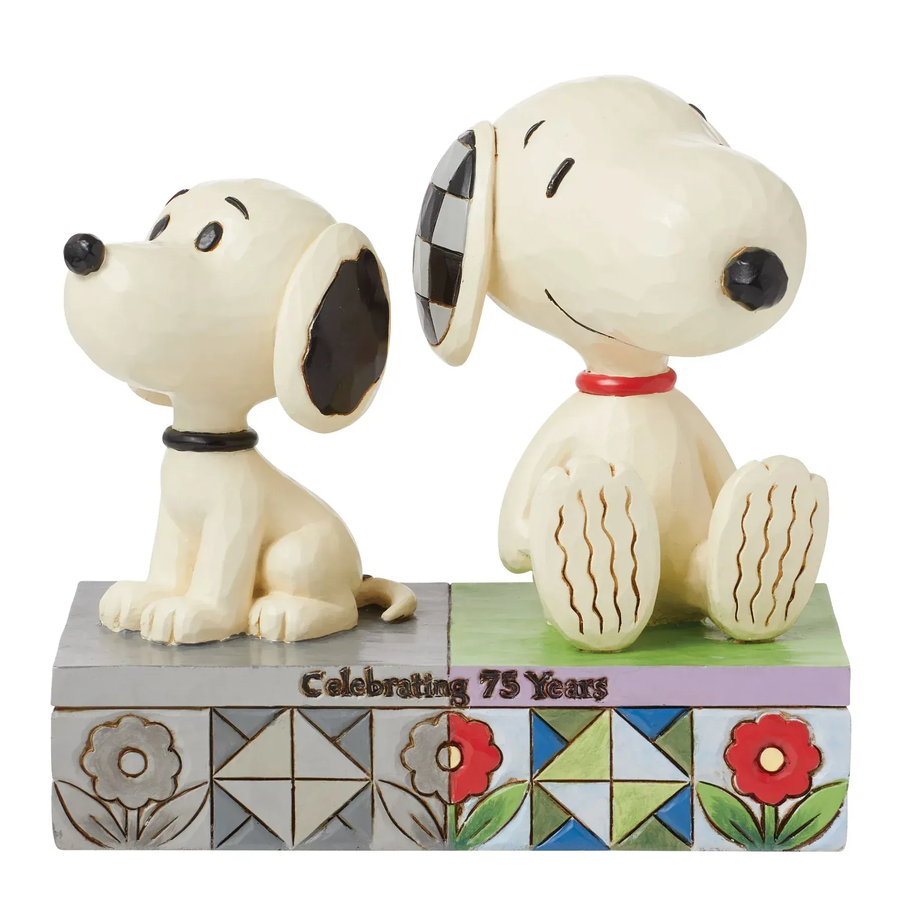 Twee Snoopy-beeldjes, een zittend en een puppy-achtig, op een sokkel met de tekst