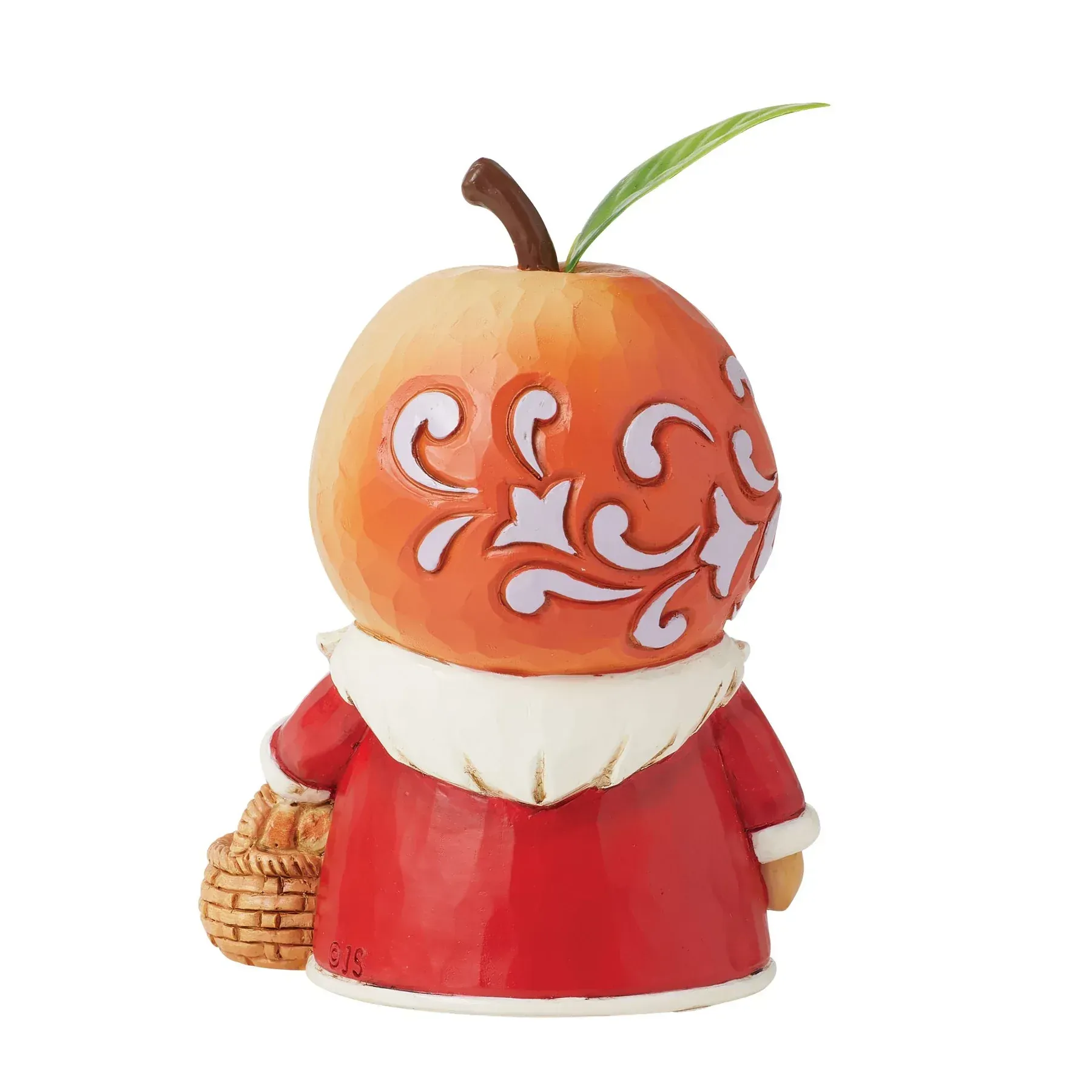 Een kerstmanfiguur met een appelvormig hoofd, die een mand met sinaasappels vasthoudt.