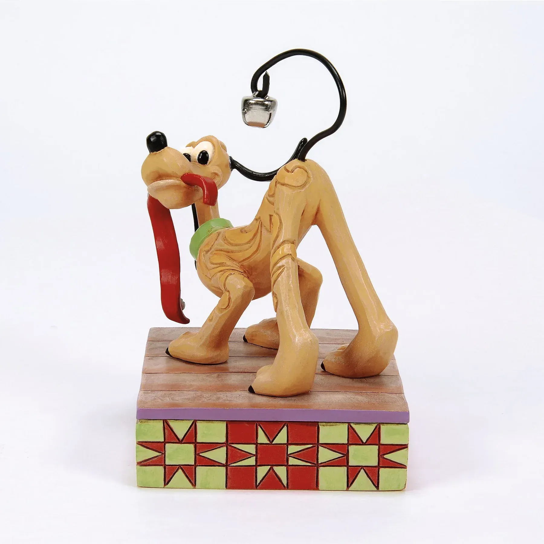 Een Pluto-beeldje in een speelse pose met uitgestoken tong, op een decoratieve sokkel met een belletje aan zijn staart.