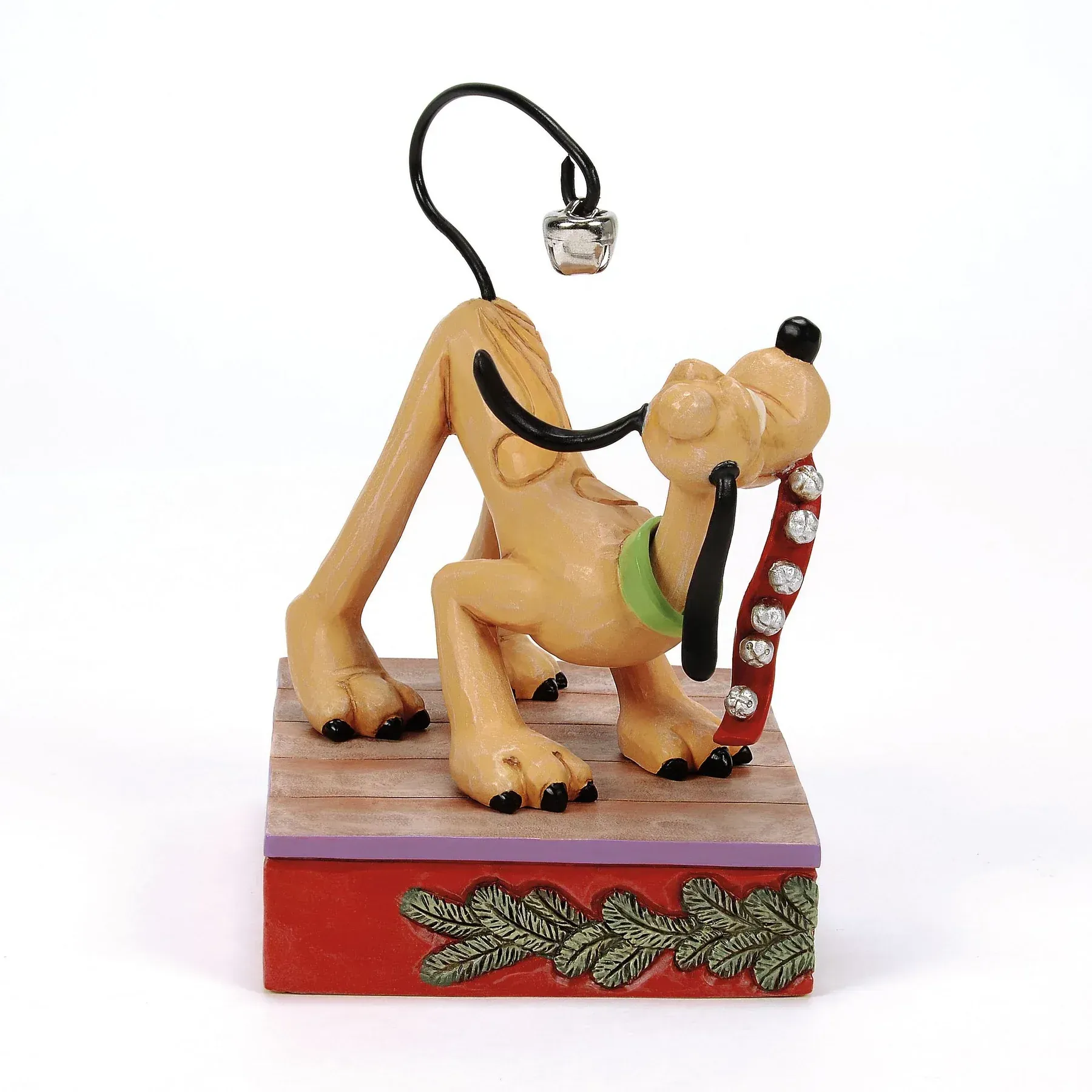 Een beeldje van de hond Pluto op een rode doosvormige voet met een gloeilamp erop, in een feestelijke pose.