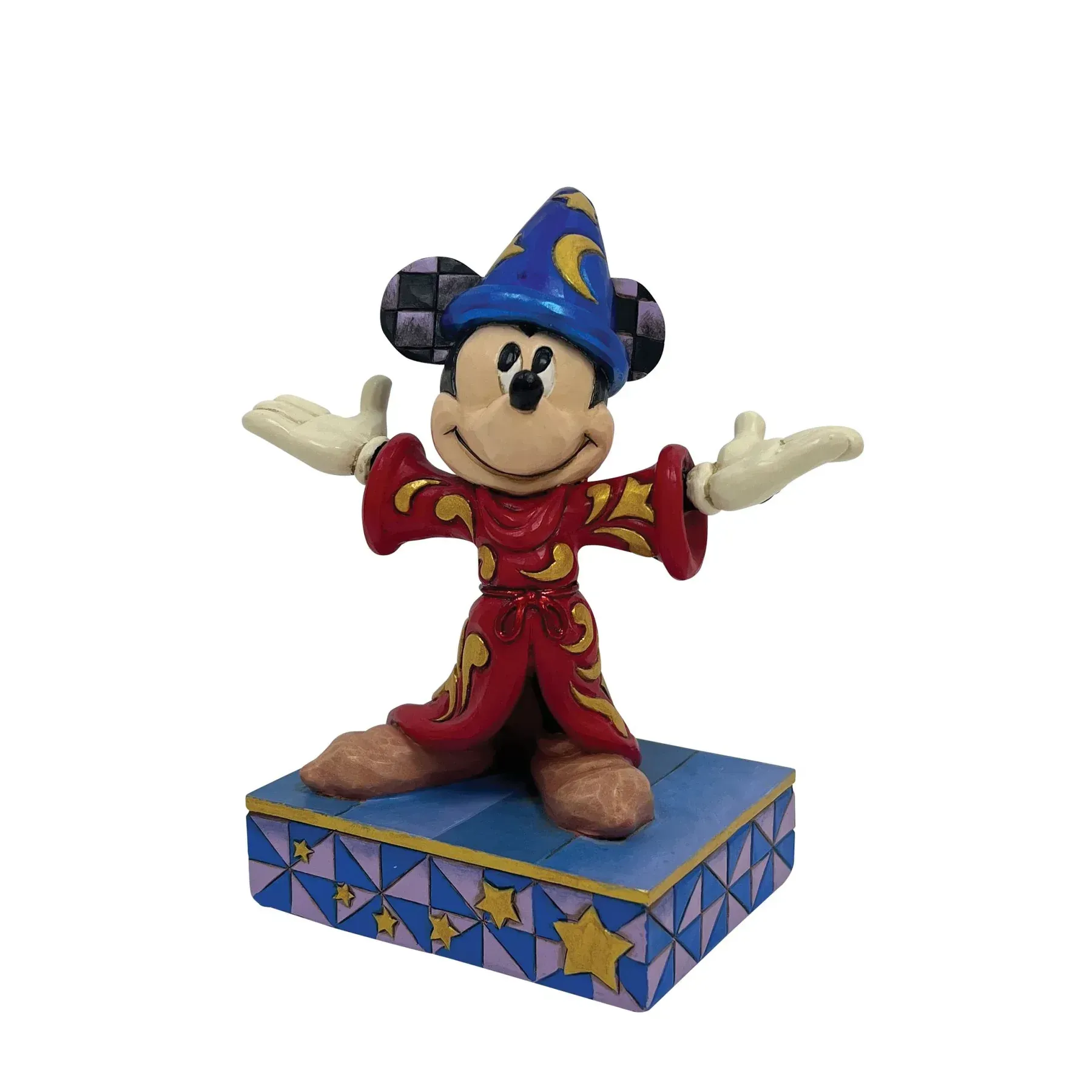 Een Mickey Mouse-figuurtje in tovenaarskleding met uitgestrekte armen, staand op een versierde sokkel.