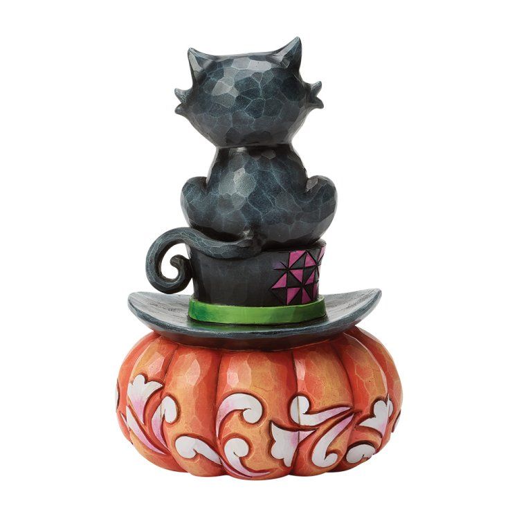 Zwarte kat zittend op een heksenhoed bovenop een oranje pompoen, Halloweenversiering.
