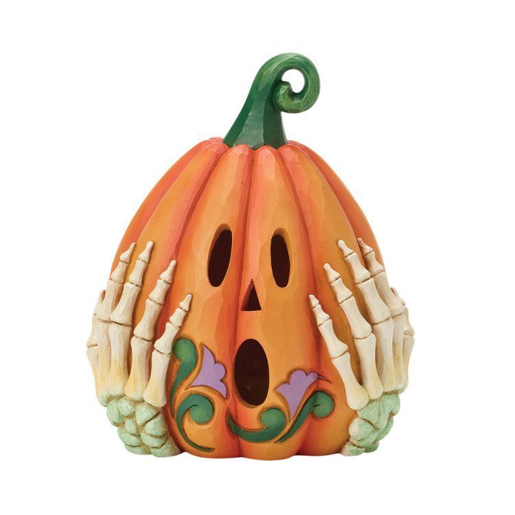Halloweenpompoenfiguurtje met skeletachtige handen die het gezicht bedekken.