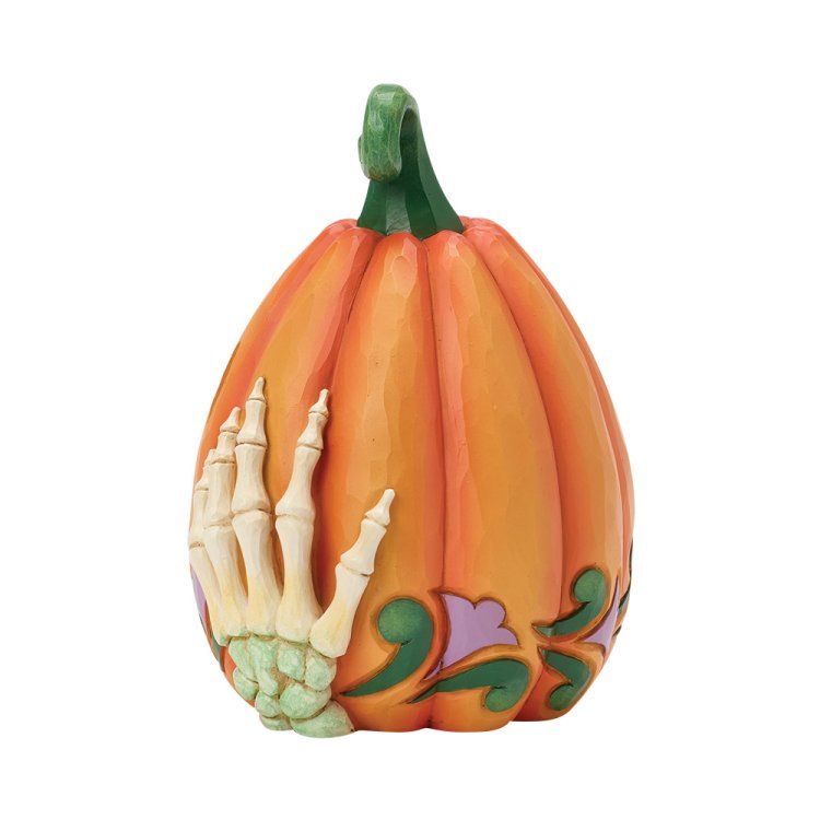 Oranje pompoen als Halloweenversiering met skelettenhanden en een lampje.
