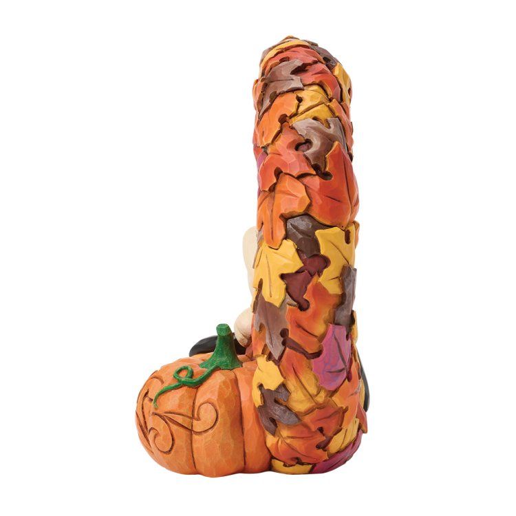 Een Snoopy-figuurtje tussen pompoenen en een krans van herfstbladeren.