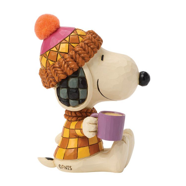 Snoopy in winterkleding, met een paarse mok in zijn hand, een muts en een trui aan.