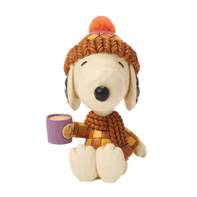 Een Snoopy-figuurtje, met gebreide muts en trui aan, die een paarse mok vasthoudt en lacht.