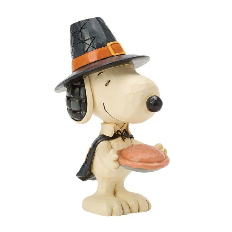 Snoopy, met heksenhoed en cape, houdt een taart vast. Beige met zwarte, oranje en bruine details.