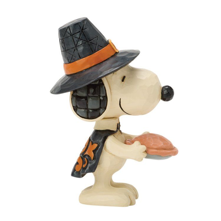 Snoopy met heksenhoed en cape, met een taart in zijn hand. Halloween-figuurtje in de kleuren crème, zwart en oranje.