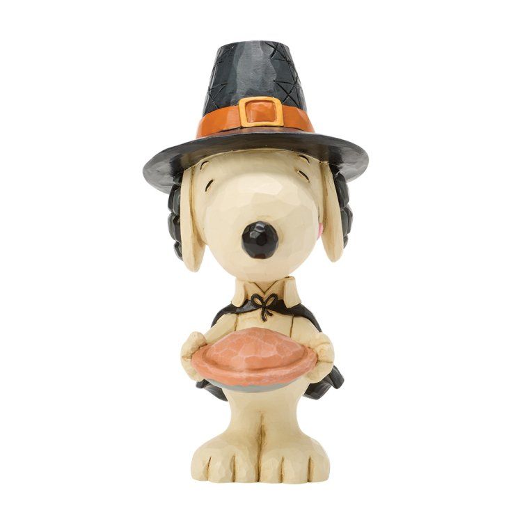Een Snoopy-figuurtje verkleed als pelgrim, met een taart in zijn hand. Hij draagt ​​een zwarte hoed met oranje rand.