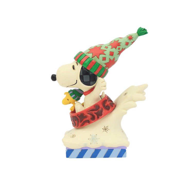 Een Snoopy-figuurtje met een kerstmuts en -sjaal, zittend op een ijzige sokkel met Woodstock.